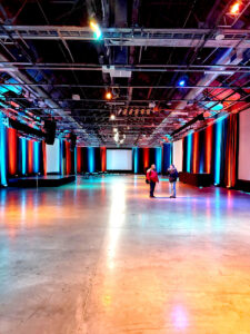 photo of vent space showing large room with red and blue lights on curtains pn the sides